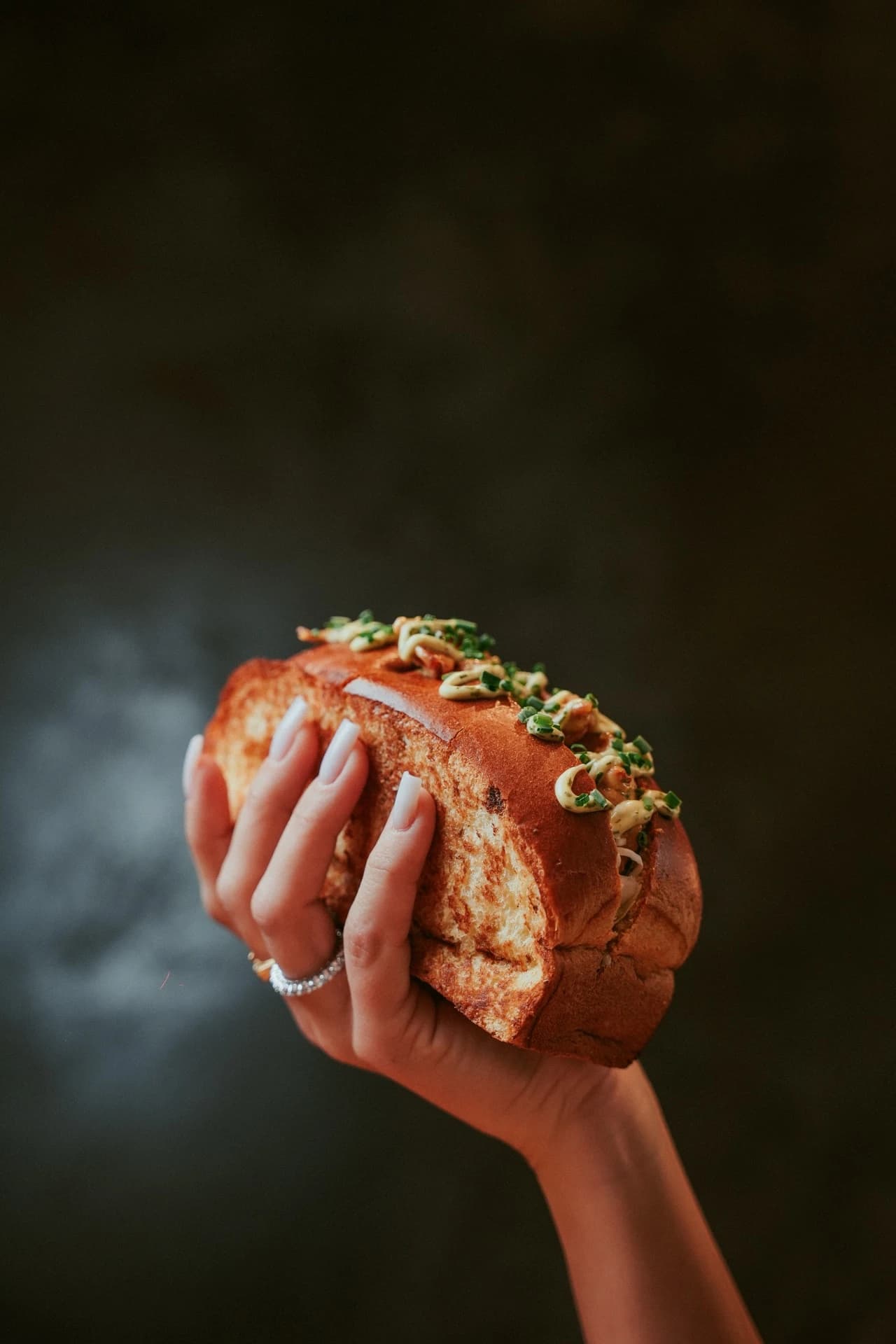 Hand holding a smoky burger